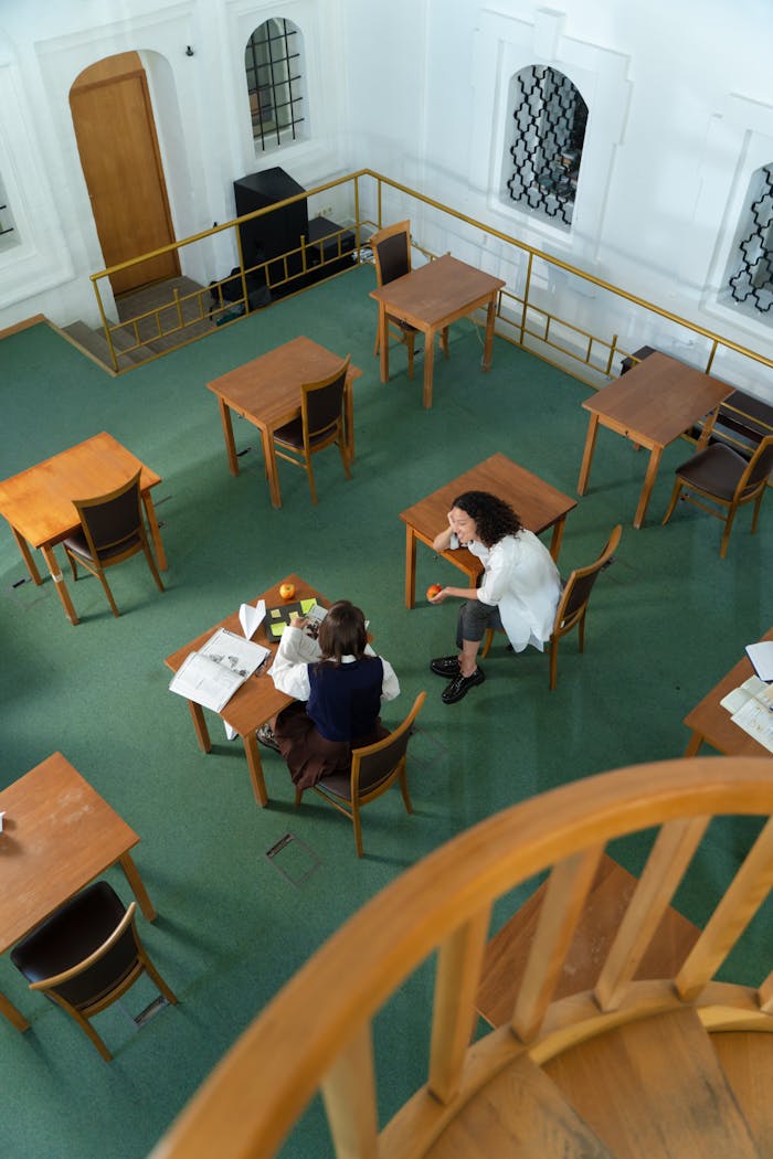 Two students study together in a spacious, quiet library.